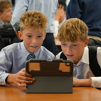 Two students on an iPad. Links to Gifts of Appreciated Securities