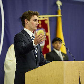 A student giving a speech. Links to Gifts of Cash, Checks, and Credit Cards