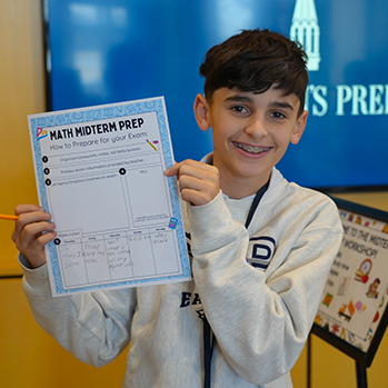 A student holding a Math Midterm Prep guide. Links to Gifts by Will