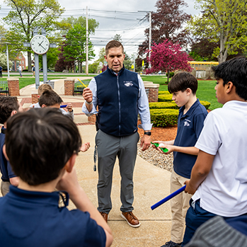 A teacher with a class outside. Links to Donor-Advised Funds
