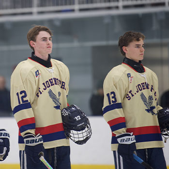 Hockey players standing on ice in uniform. Links to Gifts of Real Estate