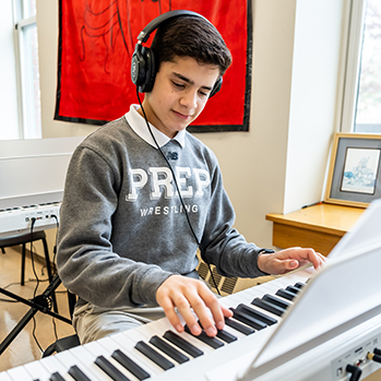 A student practicing on the electric piano. Links to Tangible Personal Property