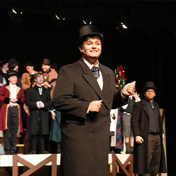 Student singing on stage during play. Links to Closely Held Business Stock