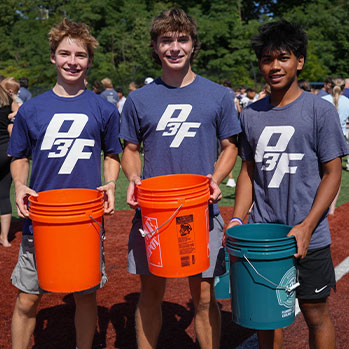 Three students standing outside holding buckets. Links to Gifts by Will